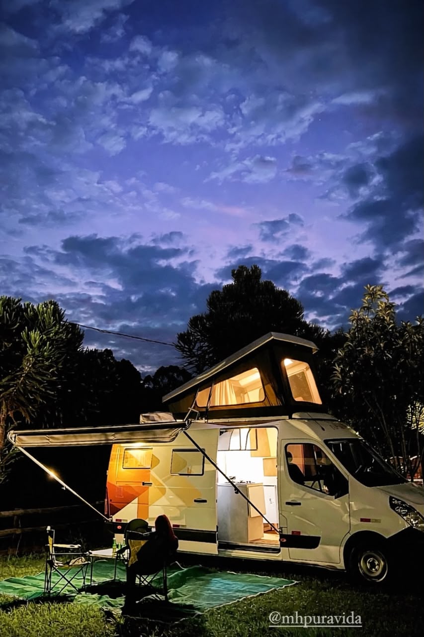Motorhome Pérola ao entardecer, com o teto elevatório levantado e o toldo lateral aberto